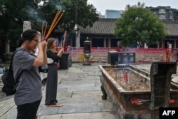 两个姑娘在北京东岳庙里烧香。(2024年8月7日)