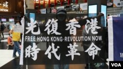 资料照:在台北车站参与支持香港行动的民众高举“光复香港时代革命”旗帜。 (2020年5月23日)