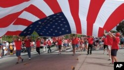2017年7月4日，加利福尼亚圣莫妮卡举行国庆游行，人们举着美国国旗。