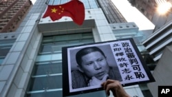 许志永的支持者在中央人民政府驻香港特别行政区联络办公室门口抗议。(2014年1月27日)